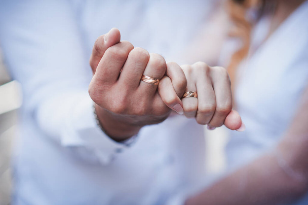 Anéis de casamento nas mãos dos recém-casados. Anéis de ouro na mão de um homem e uma mulher - Foto, Imagem