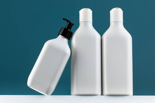 A set of cosmetic bottles on a white shelf with a place for your logo. The concept of routine body skin and hair care, toiletries. - Photo, Image