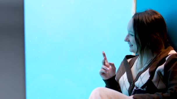 teini-ikäinen tyttö istuu akvaarion lasilla, jossa tiivisteet uivat merileijonat hän on onnellinen hymyillen nauraa iloa henkilön lapsi näyttää sormea ampua video tuttuja Vancouver akvaario, BC, Kanada - Materiaali, video