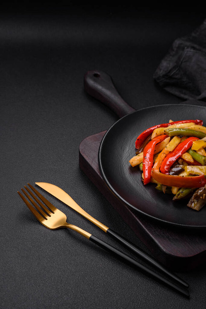 Delicious vegetables steamed peppers, asparagus beans and potatoes sliced with soy sauce on a dark concrete background - Valokuva, kuva