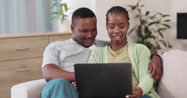 Love, laptop and happy couple on a sofa for streaming, subscription and entertainment in their home. Online, browsing and black woman with man on a couch embrace, talking and watching movie or film. - Séquence, vidéo