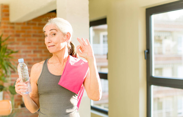 senior pretty woman feeling happy, showing approval with okay gesture. fitness concept - Foto, imagen