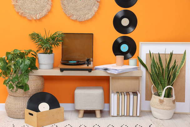 Stylish turntable with vinyl record on console table in cozy room - Photo, image