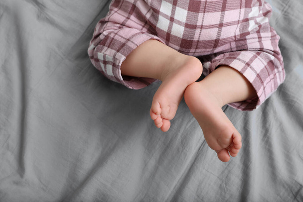 Little baby in pajamas on bed, top view. Space for text - Foto, imagen