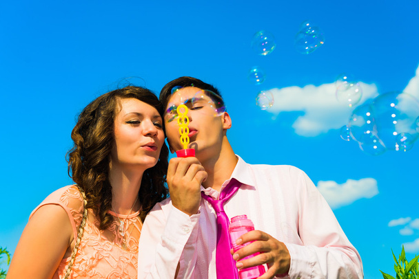 O jovem casal feliz com bolhas ensaboadas
. - Foto, Imagem