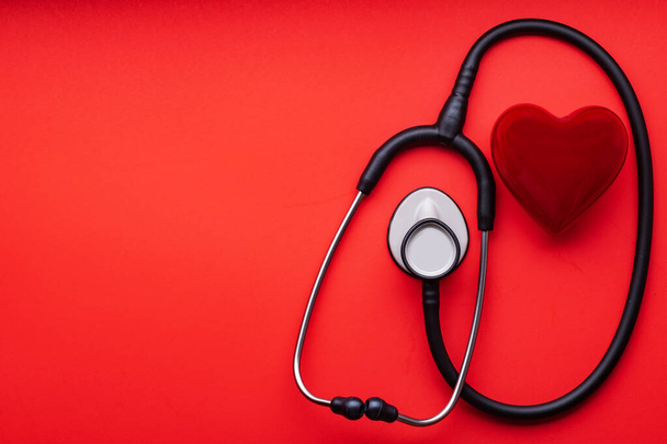 stethoscope and red heart on a red background. View from above. Space for text. - 写真・画像