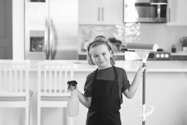 Dzieci pomagające w sprzątaniu domu. Pokojówka w domu. słodkie dziecko chłopiec pomaga w sprzątaniu w kuchni wnętrze backdround - Zdjęcie, obraz