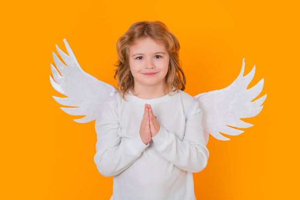 Valentines day. Blonde cute child with angel wings on a yellow studio background. Happy angel child - Foto, Bild