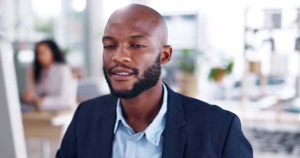 Face, smile and black man in office at computer with motivation, confidence and trust. Portrait, business and happy male employee working on desktop with pride, planning and commitment to happiness. - Footage, Video