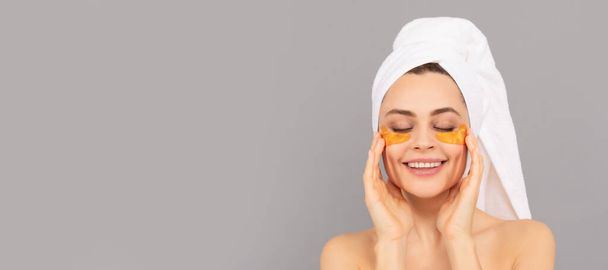 happy lady with terry towel use facial golden eye patch for skin, spa. Beautiful woman isolated face portrait, banner with mock up copy space - Photo, Image