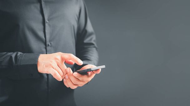 男は携帯電話で自宅で無線LANに接続するウェブサイトのソーシャルネットワークを表示します。男性の手は、インターネットを閲覧するためにセンサー画面に触れるスマートフォンモデルを保持。仮想通信の概念. - 写真・画像