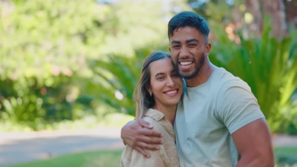 Park, hug and face of happy interracial couple for bonding, quality time and relaxing on weekend date. Relationship, dating and portrait of man and woman embrace for trust, commitment and romance. - Footage, Video