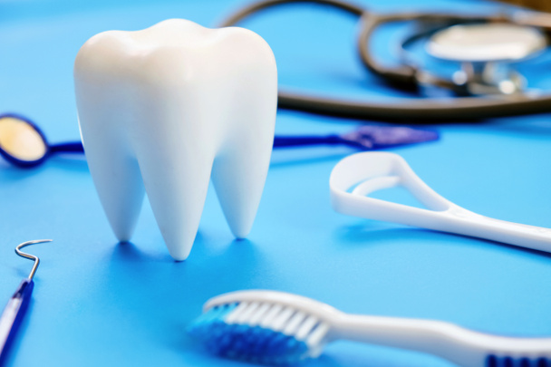Modelo dental y equipo dental sobre fondo azul, imagen conceptual de fondo dental. antecedentes de higiene dental - Foto, imagen