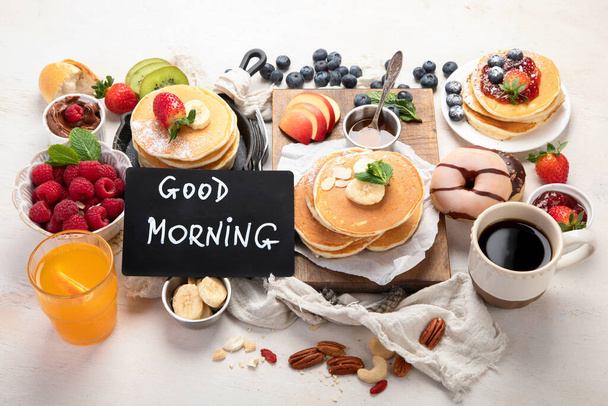 Continental breakfast. Coffee, jam, pancakes, maffins. White background. Family breakfast table. Top view. - Zdjęcie, obraz