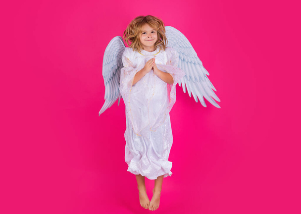 Angel child jump, kids jumping, full body in movement. Cute kid with angel wings isolated on pink studio background. Little angel, valentines day. Angelic kids - Photo, image