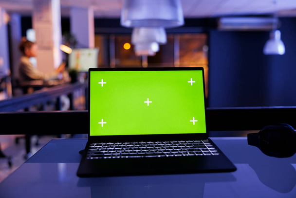 Laptop komputer z zielonym ekranem makiety klawisz chroma z izolowanym wyświetlaczem stojącym na biurku, Businesswoman pracy w godzinach nadliczbowych w strategii inwestycyjnej w celu zwiększenia zysku firmy. Koncepcja przedsiębiorstwa - Zdjęcie, obraz
