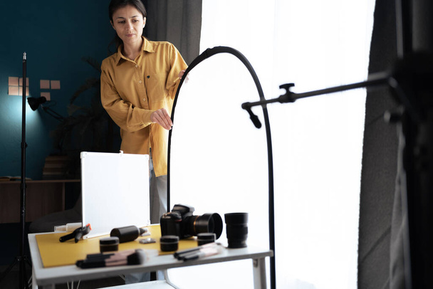 Young woman with professional camera taking skincare beauty product photo in studio. Copy space - Φωτογραφία, εικόνα