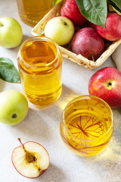 Jus de pomme dans un verre et pommes fraîches sur une table en pierre. Automne boisson vitaminée jus de pomme.  - Photo, image