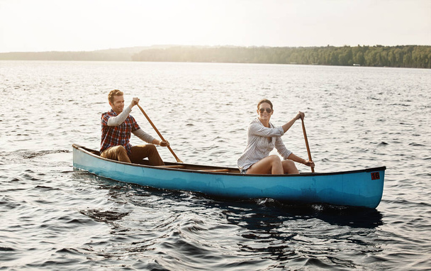 Entspannte Kanufahrten auf dem See. Porträt eines jungen Paares bei einer Kanutour auf dem See - Foto, Bild