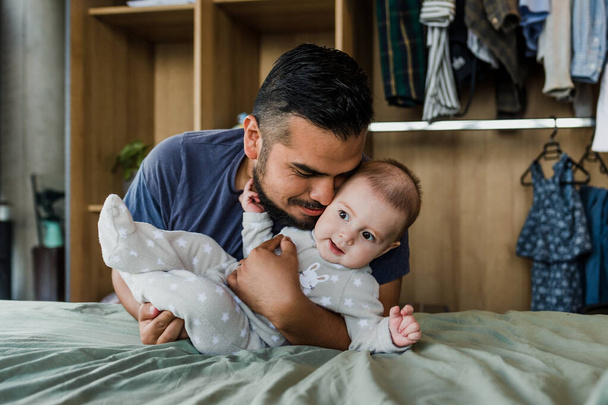 Latijnse vader omarmt zijn schattige baby zoon in Mexico Latijns-Amerika, Latijns-Amerikaanse familie - Foto, afbeelding