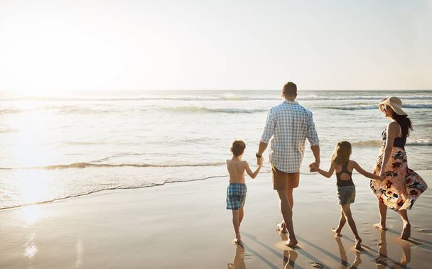 Лето время для поездок на пляж. семья из четырех человек проводит день на пляже - Фото, изображение