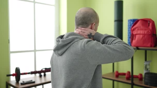 Νεαρός φαλακρός άνδρας που υποφέρει για αυχενικό πόνο στο αθλητικό κέντρο - Πλάνα, βίντεο