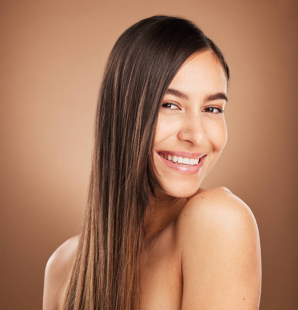 Hair care, beauty and portrait of woman in studio for wellness, treatment and health on brown background. Salon aesthetic, smile and face of happy girl with cosmetics, hairstyle and natural glow. - Valokuva, kuva