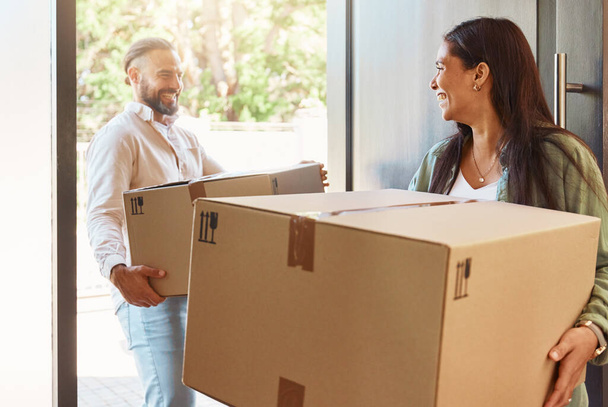 Happy couple, boxes and moving in new home, property or real estate with cardboard box indoors. Man, woman and smile in happiness for mortgage loan, investment or purchase carrying packages inside. - Foto, Imagem