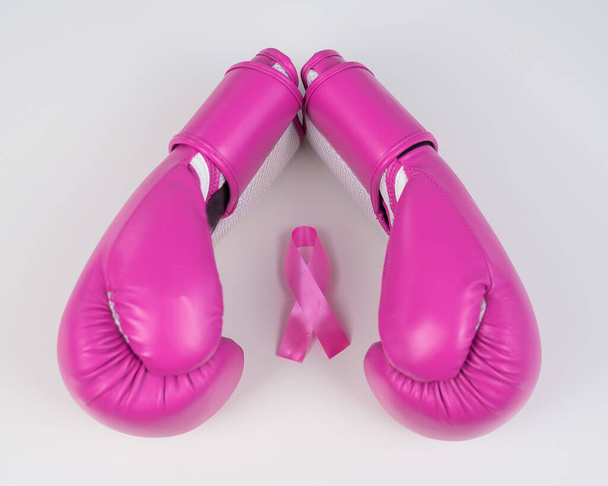 Pink boxing gloves and a pink silk ribbon on a white background. Breast cancer concept - Φωτογραφία, εικόνα