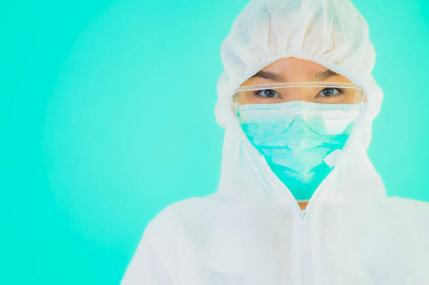 Portrait schöne junge asiatische Ärztin tragen ppe oder persönliche Schutzausrüstung zum Schutz vor Coronavirus oder covid19 auf blauem Hintergrund isoliert - Foto, Bild