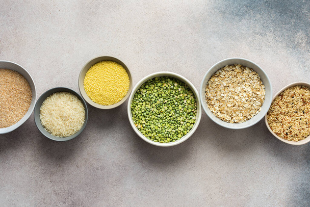 Various grain cereals in bowls on a light background, top view - Valokuva, kuva