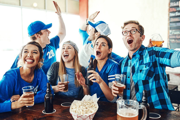 Głośni i dumni fani sportu. grupa przyjaciół wiwatująca podczas oglądania meczu sportowego w barze - Zdjęcie, obraz