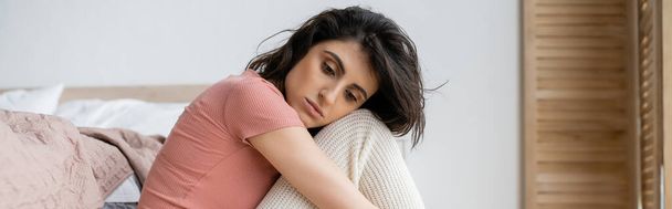 Frustrated brunette woman sitting near bed at home, banner  - Φωτογραφία, εικόνα