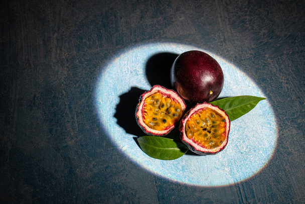 Passion fruits on dark background. Set of whole and half of fresh passion fruit. place for text, top view, - Photo, Image