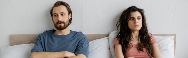 Δυσάρεστο ζευγάρι με δυσκολίες στη σχέση κάθεται στο κρεβάτι στο σπίτι, πανό  - Φωτογραφία, εικόνα