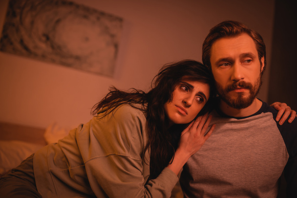 Sad woman hugging bearded boyfriend in bedroom at home  - Photo, Image