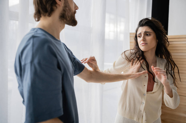 Afraid woman standing near abusive boyfriend during relationship difficulties at home  - Fotoğraf, Görsel