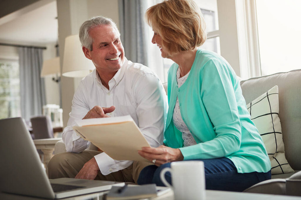 The numbers are looking good. a mature couple going over their finances at home - Foto, Imagen