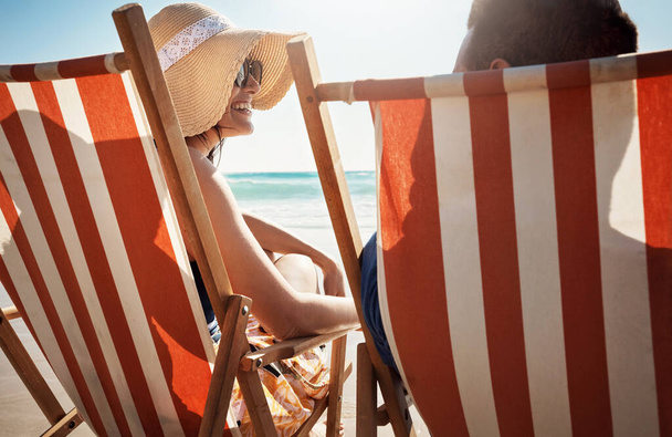 夏の恋人が何をするか。若いカップルがビーチで椅子にくつろぎ - 写真・画像