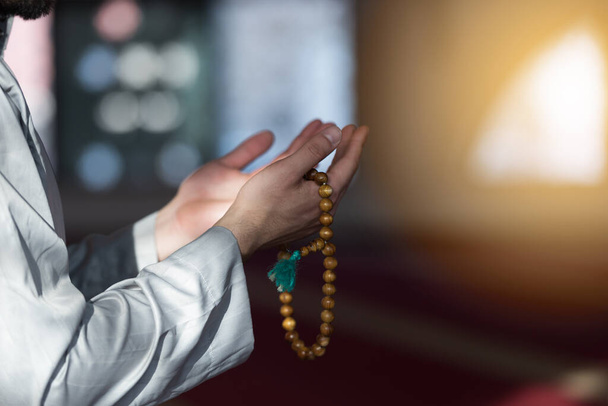 Hand of male muslim praying with mosque interior background during ramadan - Photo, Image