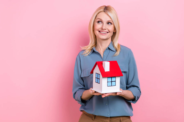 Photo of attractive senior business lady realtor hold cute little house building sell real estate isolated pink color background. - Foto, afbeelding