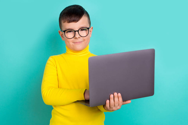Photo of clever boy pupil stay home quarantine study online classes with netbook isolated cyan color background. - Foto, imagen