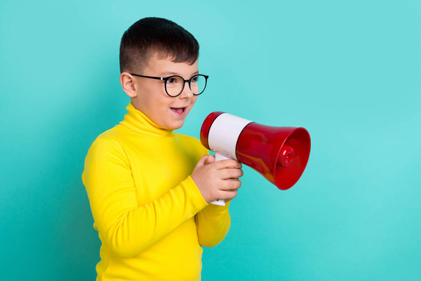 Photo profile side of school boy speaking in microphone megaphone advertise discounts isolated on cyan color background. - Foto, imagen