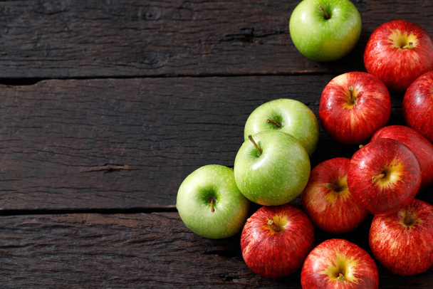 friss piros és zöld alma a fapadlón - Fotó, kép