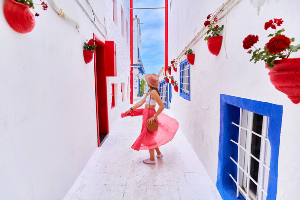 Romantic young traveler girl wearing pink skirt and hat walking alone the aegean street in Bodrum  - Zdjęcie, obraz