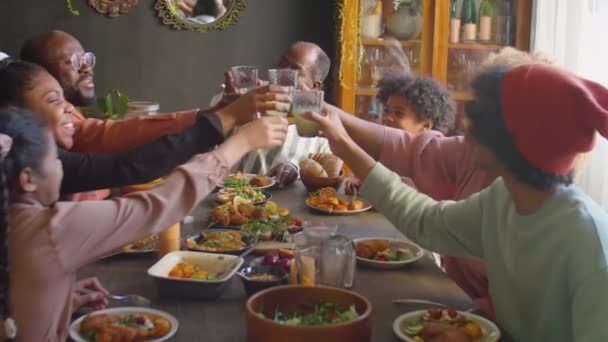 Big afro-américain famille cliquetis verres dans un pain grillé, boire de la limonade et manger un repas tout en ayant des vacances dîner à la maison - Séquence, vidéo