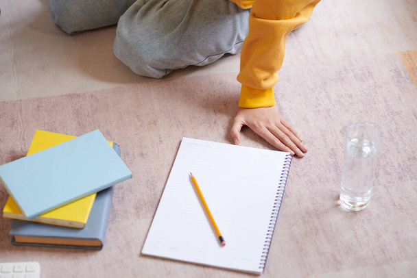 Bayan öğrencinin önünde yere boş sayfalar ve kalemle yazılmış bir defter. - Fotoğraf, Görsel