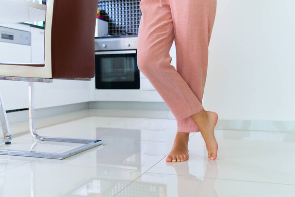 Female barefoot legs on heated warm floor at home kitchen   - Zdjęcie, obraz