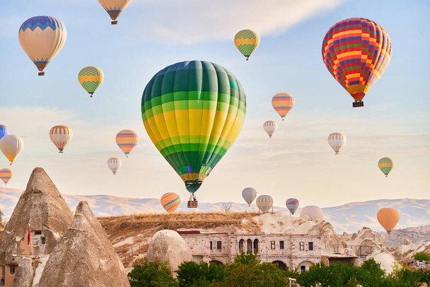 Landscape of fabulous Kapadokya. Colorful flying air balloons in sky at sunrise in Anatolia. Vacations in beautiful destination in Goreme, Turkey  - Foto, Imagen