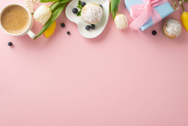 Świętuj Dzień Matki z modnej koncepcji nakrycia stołu. Widok z góry płaski układ talerzy z podlewającymi ustami babeczki, prezenty, kawa, tulipany na pastelowym różowym tle z pustym miejscem na wiadomość - Zdjęcie, obraz
